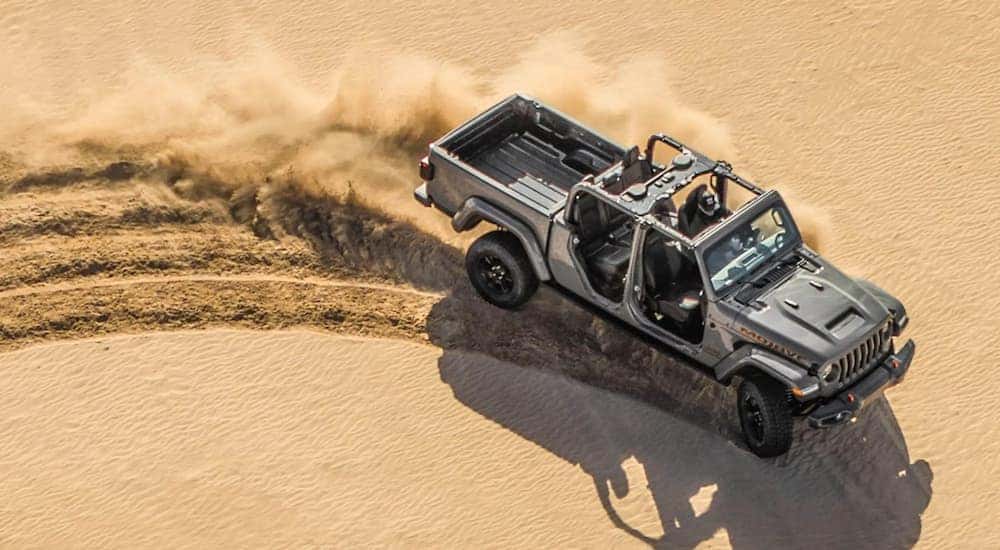 A silver 2021 Jeep Gladiator Mojave is shown off-roading in the desert.