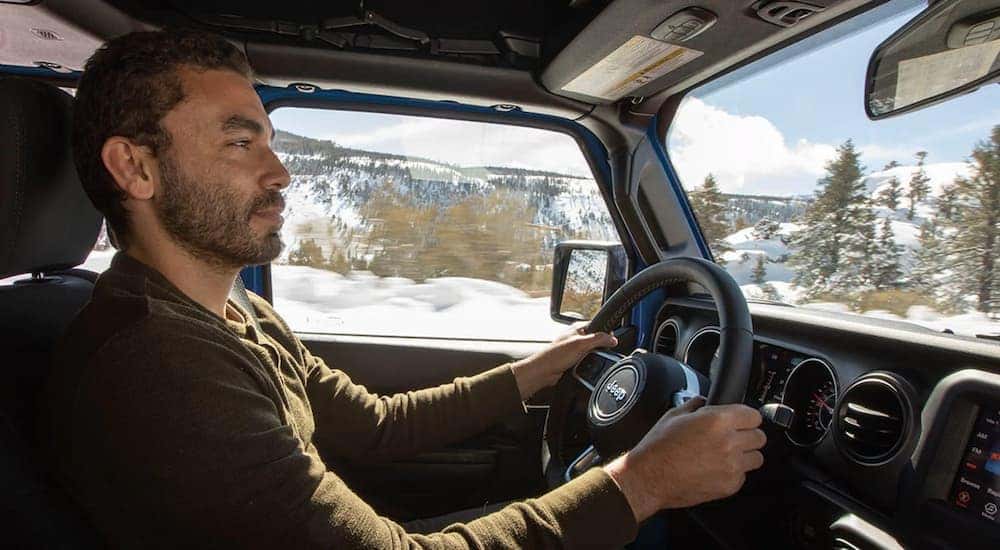 A man is shown driving a 2021 Jeep Gladiator Overland.