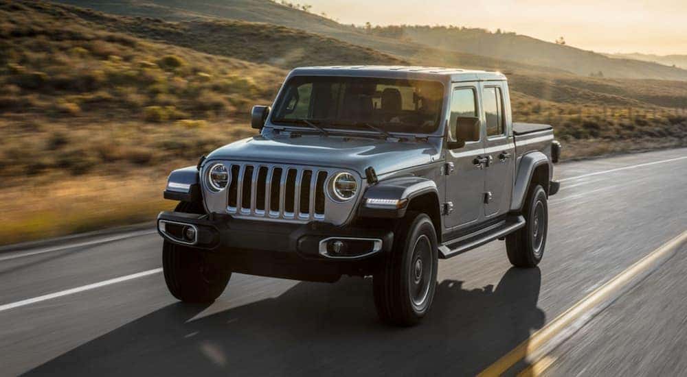 A silver 2021 Jeep Gladiator Sport is shown leaving a California Jeep Gladiator dealer.