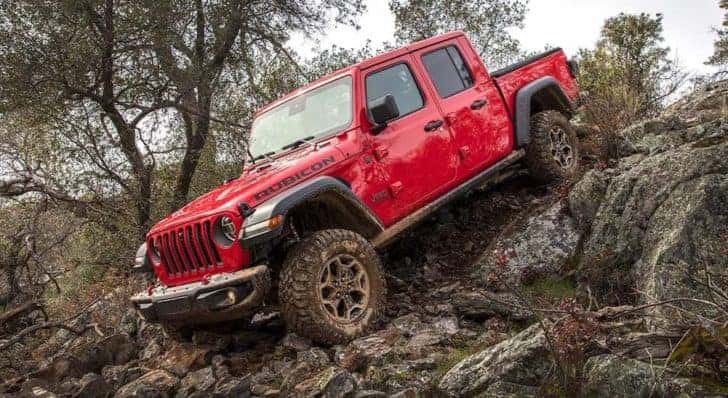 A red 2021 Jeep Gladiator Rubicon is shown driving down a steep rocky trail.