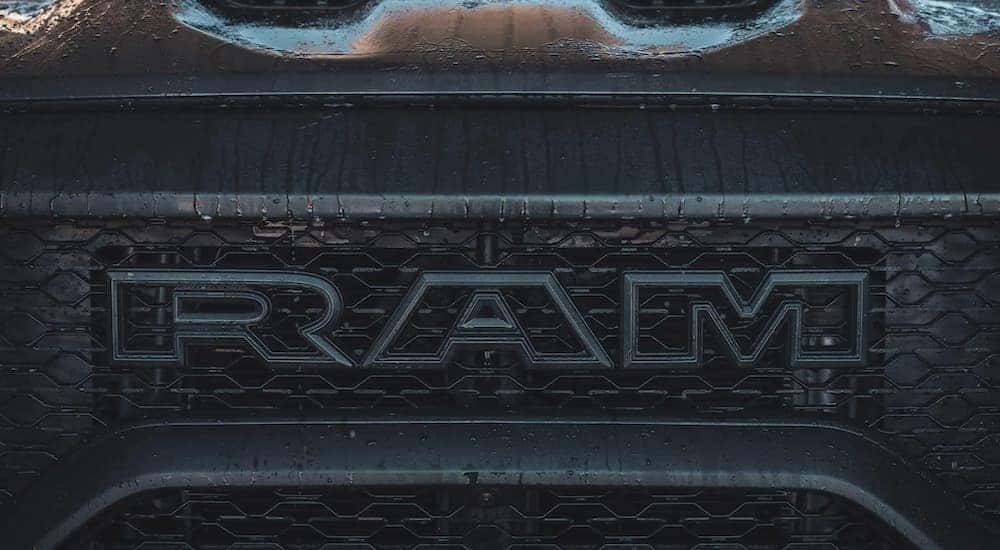 The grille of a black 2022 Ram 1500 TRX shows the RAM logo in close up.
