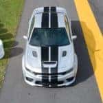 A silver 2020 Dodge Charger with black racing stripes is shown from a high angle on the race track.