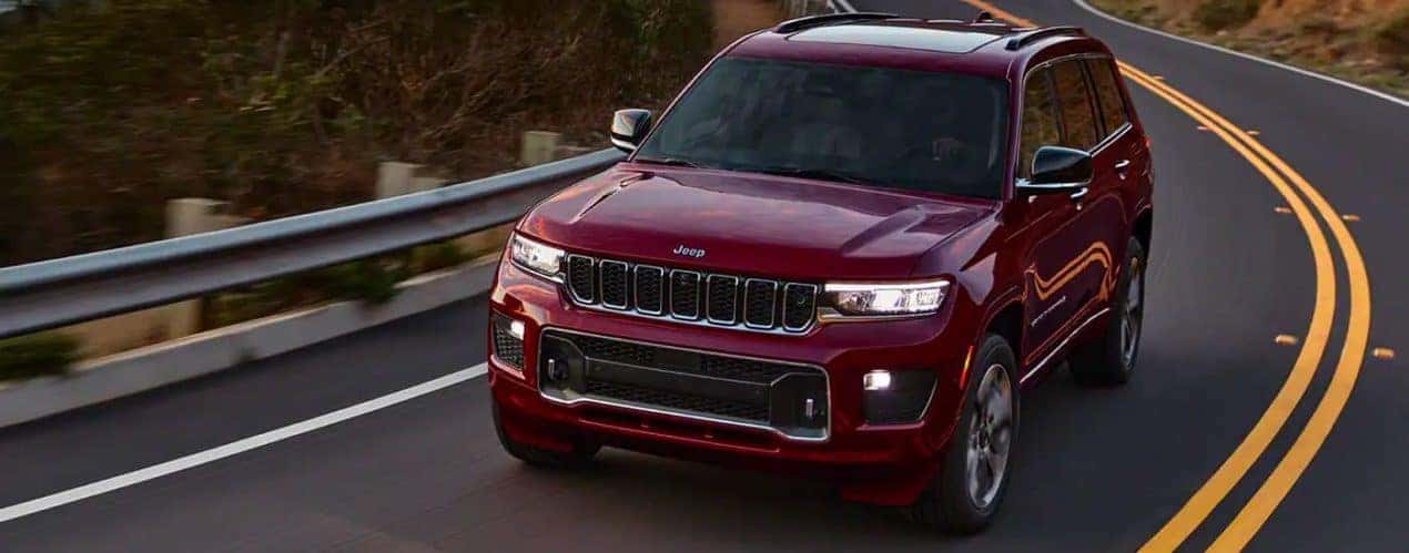 A red 2021 Jeep Grand Cherokee L is shown from a high angle on a highway after winning a 2022 Jeep Grand Cherokee L vs 2022 Nissan Pathfinder comparison.