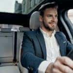A person is smiling while driving a car.