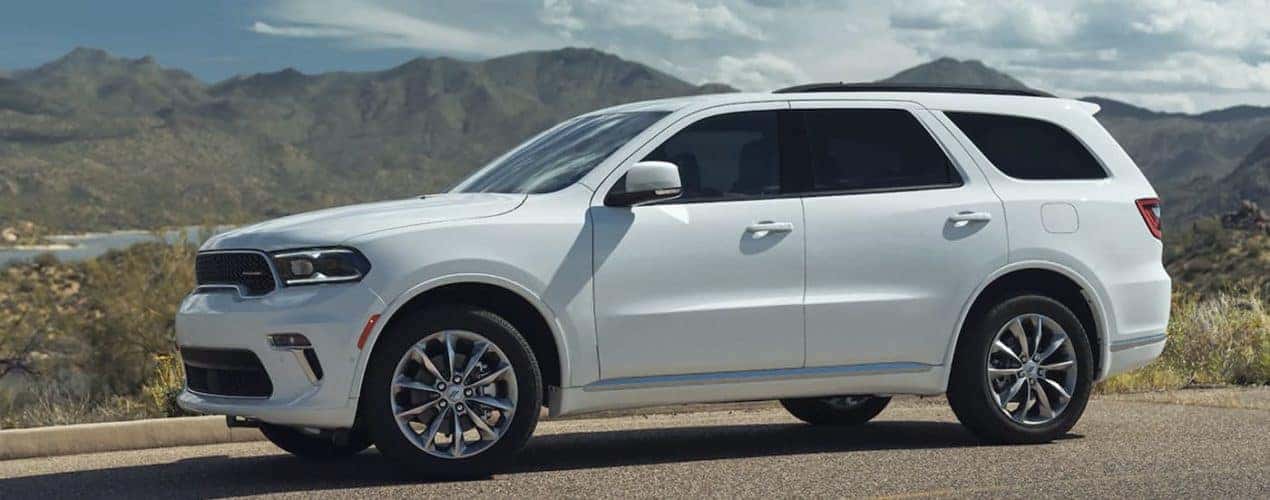 A white 2022 Dodge Durango is shown from the side parked in front of a mountain.