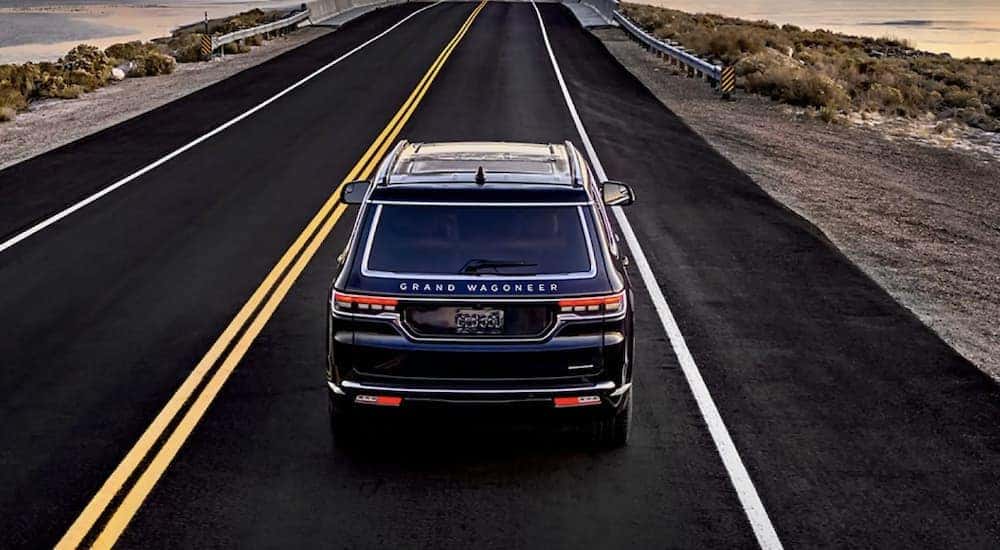 A black 2022 Grand Wagoneer is shown from above driving on an open road.