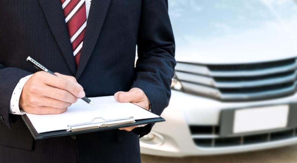 A salesman is shown holding warranty information on clipboard.