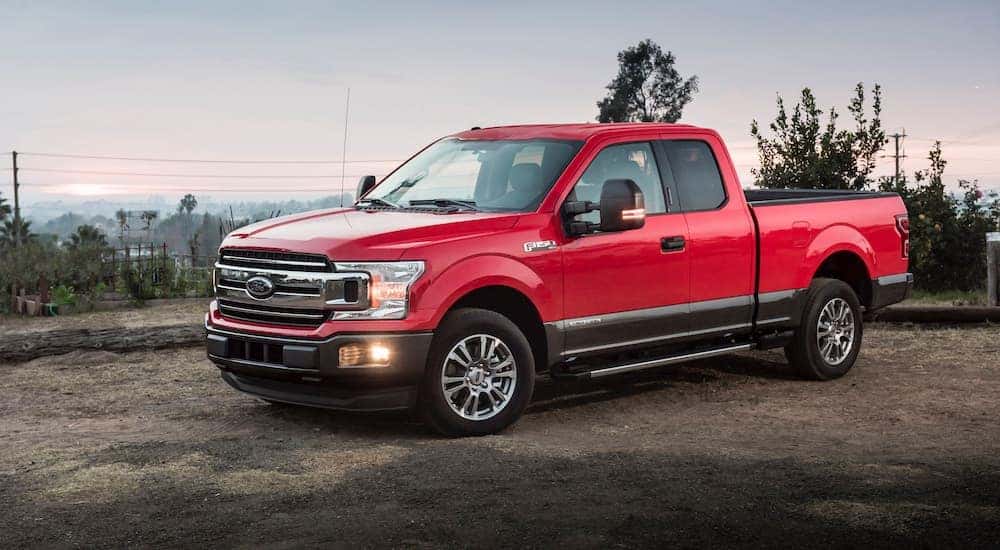 A red 2018 Ford F-150 is shown parked on a dirt trail after viewing used trucks near you.