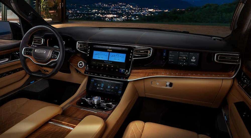 The black and brown interior of a 2022 Wagoneer shows the steering wheel and center console.