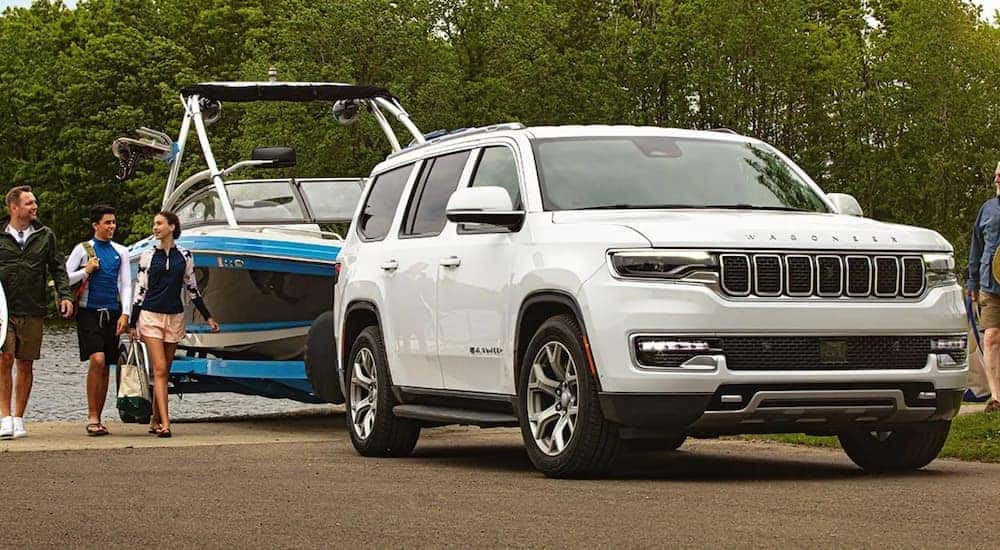 A white 2022 Wagoneer is shown towing a boat.