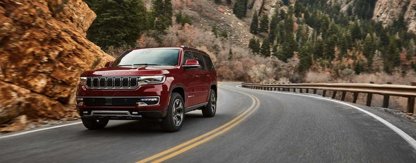 A red 2022 Wagoneer is shown from the front driving on an open road.