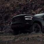A black 2022 Ram 1500 is shown driving up a steep dirt trail.