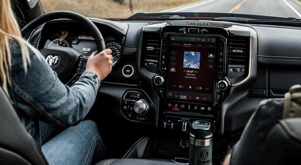 A woman is shown driving a 2022 Ram 1500.