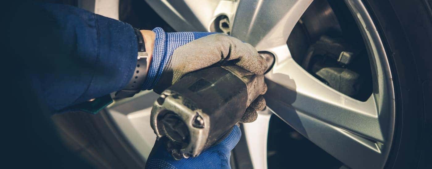 A mechanic is show preforming a tire rotation during a Ram truck service.