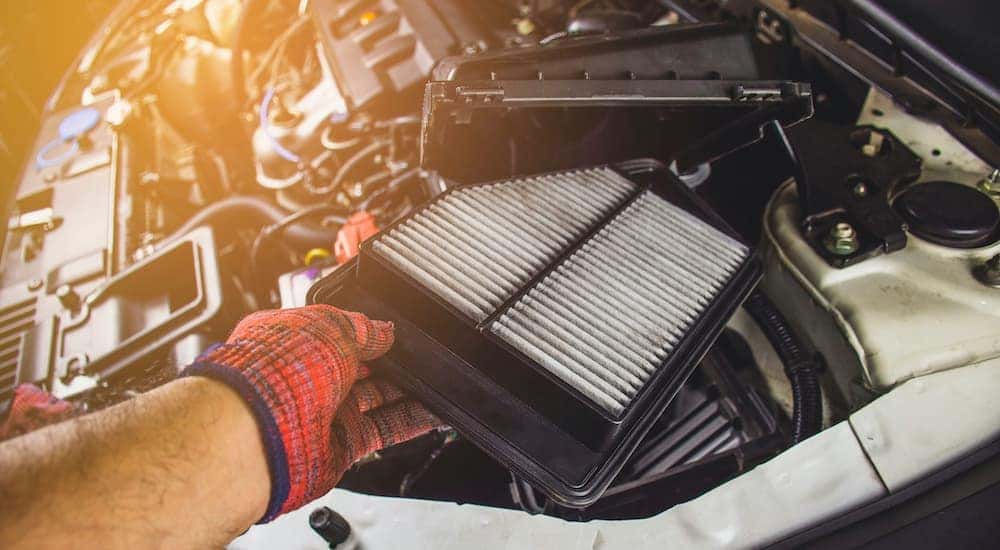 A mechanic is shown removing an old air filter during a Ram truck service.