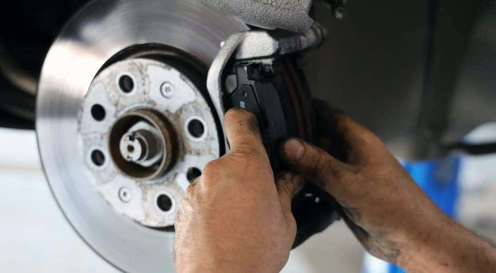 A mechanic is shown changing a brake pad.
