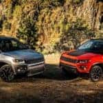 A grey and an orange 2018 Jeep Compass are shown from the front parked at an angle offroad after the owners searched 'used Jeep Compass'.