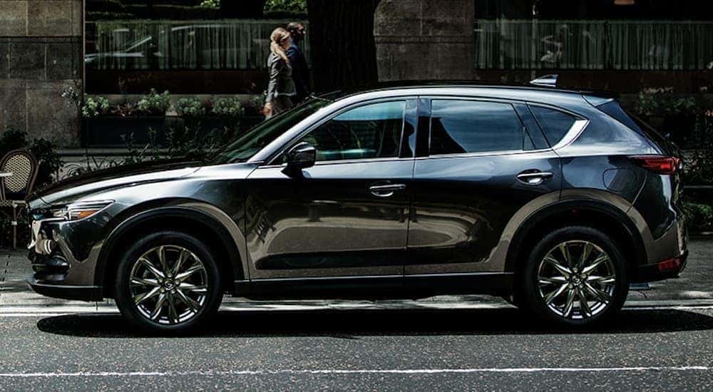 A black 2020 Mazda CX-5 is shown from the side parked in a city.