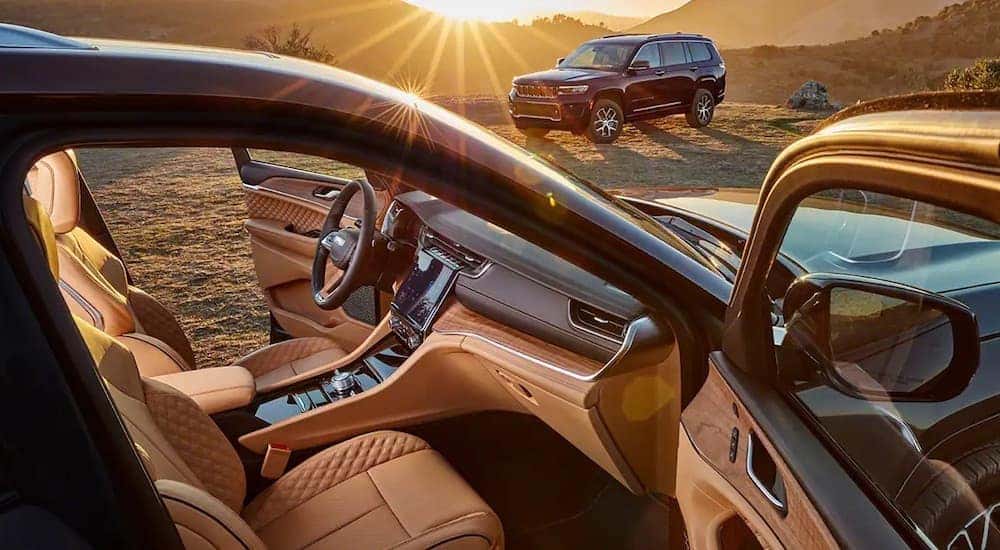 The interior of a black 2022 Jeep Grand Cherokee is shown from the passenger door opening.