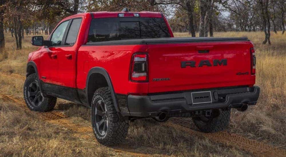 A red 2022 Ram 1500 Rebel is shown from behind in the forest.