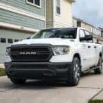 A white 2022 Dodge Ram is shown from the front while parked in front of a house after the owner searched 'Ram buyers guide'.