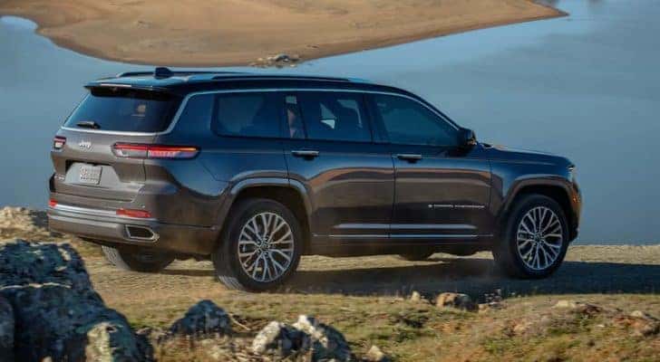 A grey 2021 Jeep Grand Cherokee L is shown from the side overlooking a body of water.