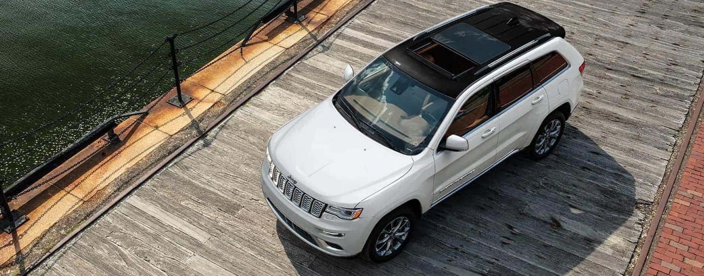 A white 2021 Jeep Grand Cherokee is shown from a high angle on a pier.