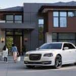 A white 2021 Chrysler 300S is shown parked outside of a modern home.