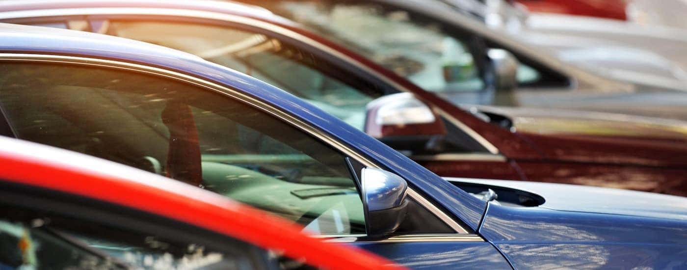 A row of used cars are shown close up.