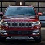 A red 2022 Wagoneer is shown front parked in front of a building.