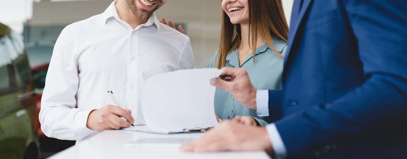A salesperson is shown going over paperwork with a couple.