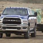 A blue 2021 Ram 2500 is shown from the front towing a trailer.