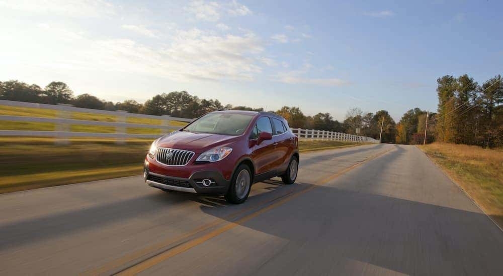 A red 2016 Buick Encore is shown from the front driving on an open road.