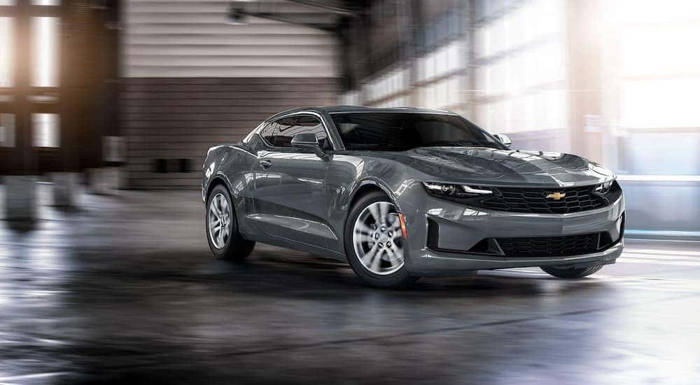 A grey 2022 Chevy Camaro LS is shown driving through a garage.