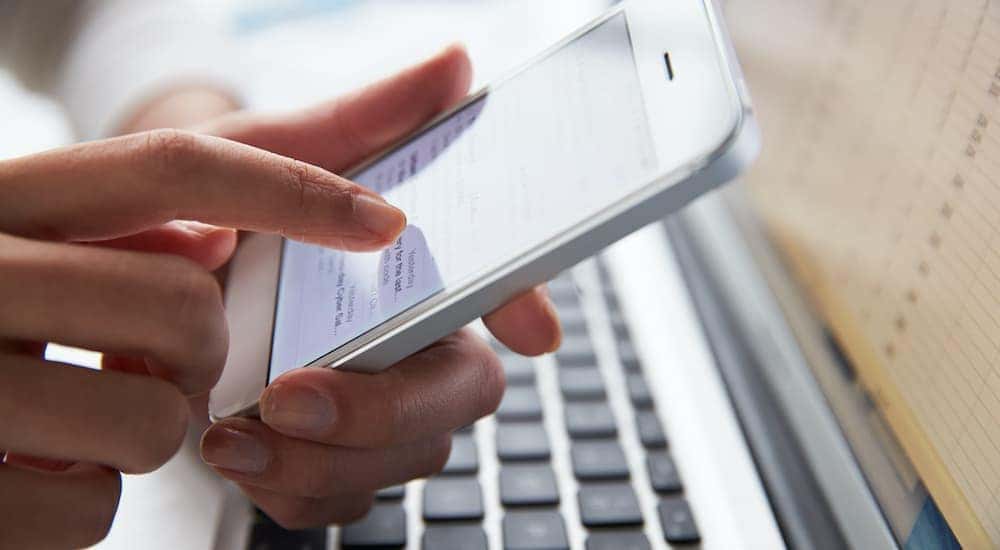 A person is shown working on a phone in a mobile office after getting a RAM truck lease.