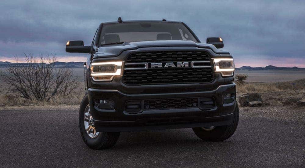 The front of a black 2022 Ram 3500 is shown parked on a rocky area.