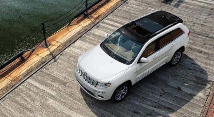 A white 2021 Jeep Grand Cherokee is shown from a high angle parked on a boardwalk.