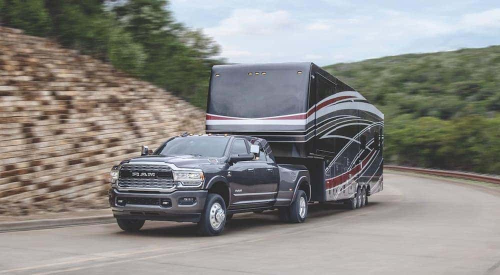 A grey 2020 Ram 3500 is shown from the front while towing a camper.
