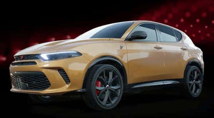 A yellow 2023 Dodge Hornet is shown angled left on a black and red background.