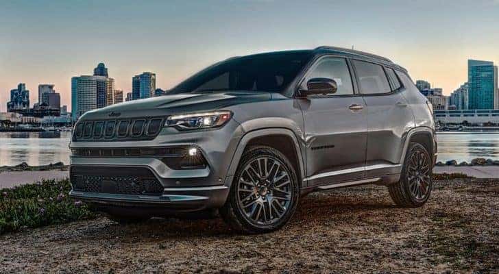 A grey 2022 Jeep Compass High Altitude is shown parked with a view of a city skyline.