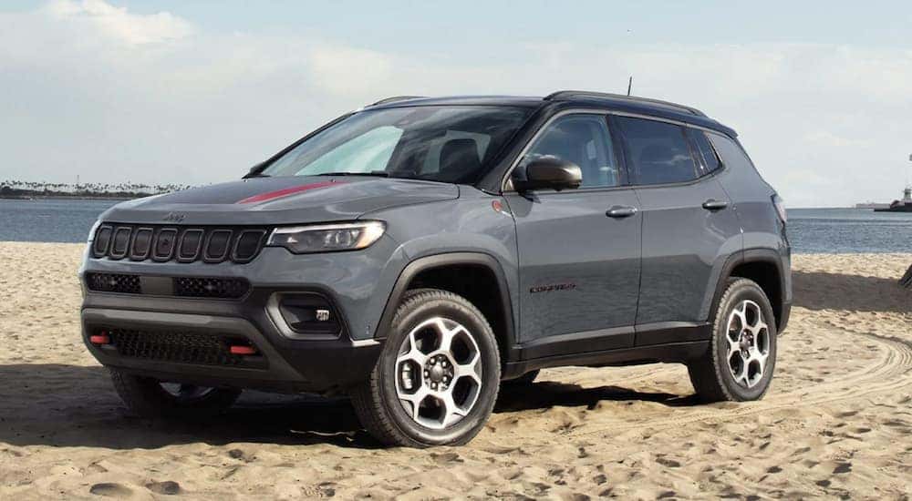 A grey 2022 Jeep Compass is shown parked on a beach.