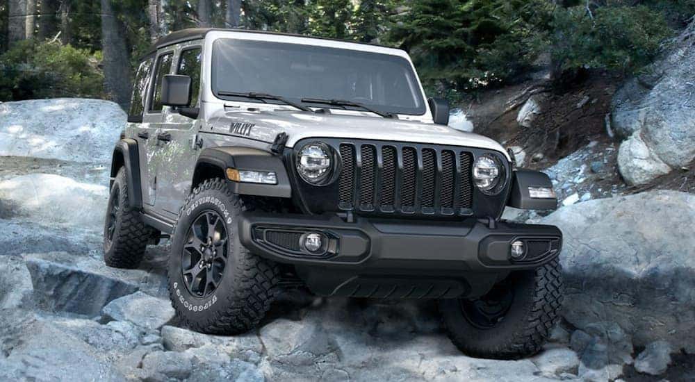 A silver 2020 Jeep Wrangler Willys is shown from the front in a rocky area after leaving a Jeep dealership Los Angeles.