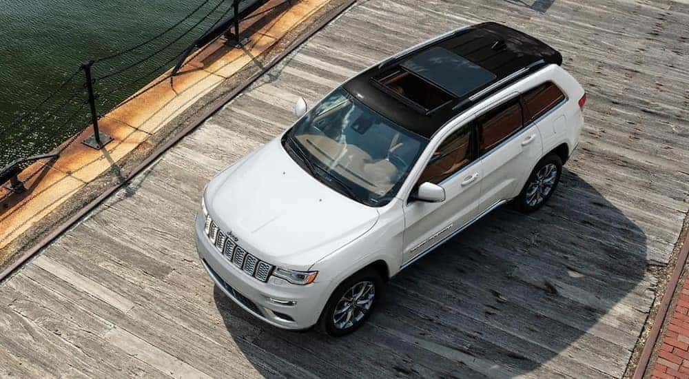 A white 2021 Jeep Grand Cherokee is shown from above parked on a dock.