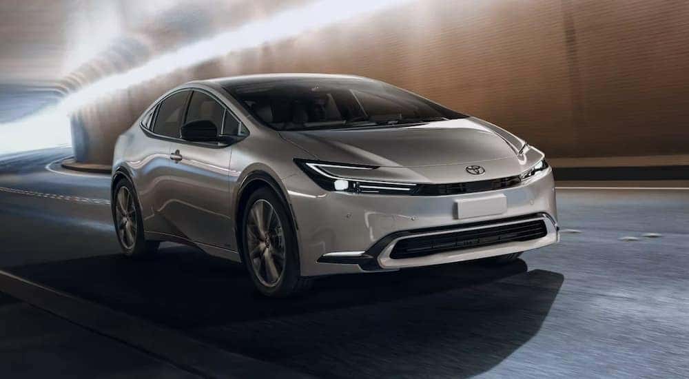 A grey 2023 Toyota Prius Limited, a popular used car for sale, is shown from the front driving through a tunnel.