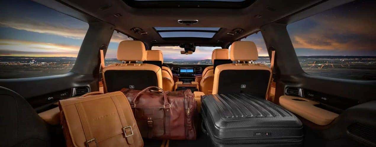 The tan interior of a 2023 Grand Wagoneer shows the rear cargo area and two rows of seating.