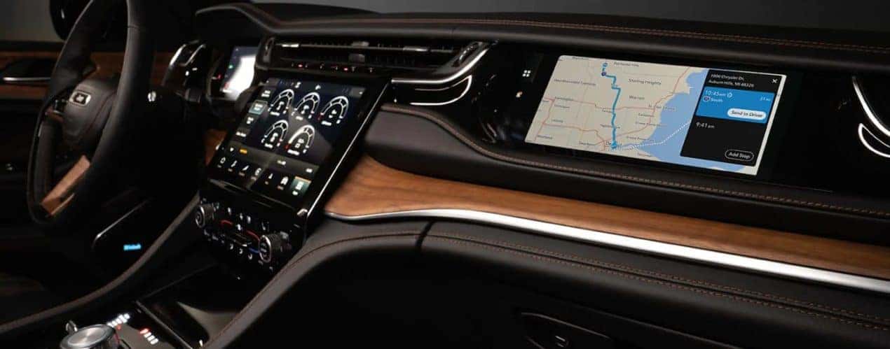 A close up of the brown and black interior of a 2023 Jeep Grand Cherokee shows the dashboard.