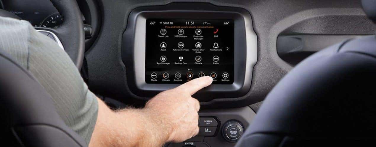 The black interior of a 2023 Jeep Renegade shows the infotainment screen.