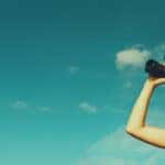 Person with binoculars looking for used SUV deals