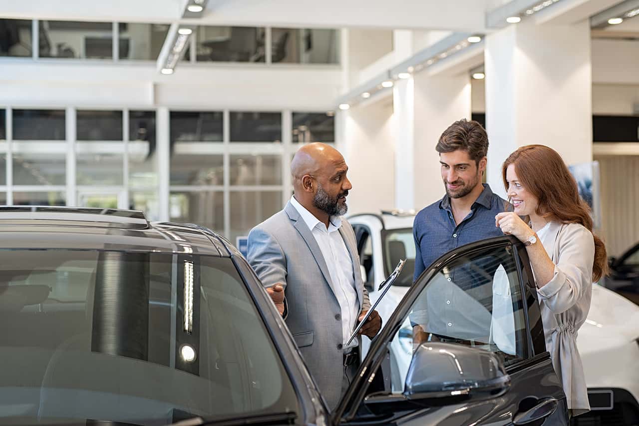 Customer talking to salesperson at an auto dealership