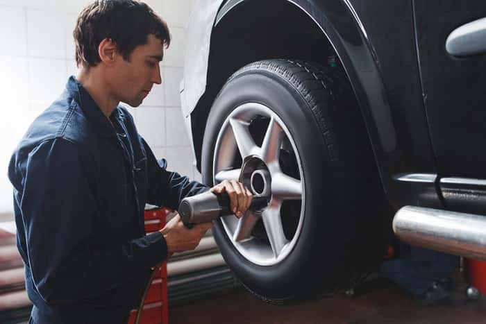 Jeep service technician rotating tires
